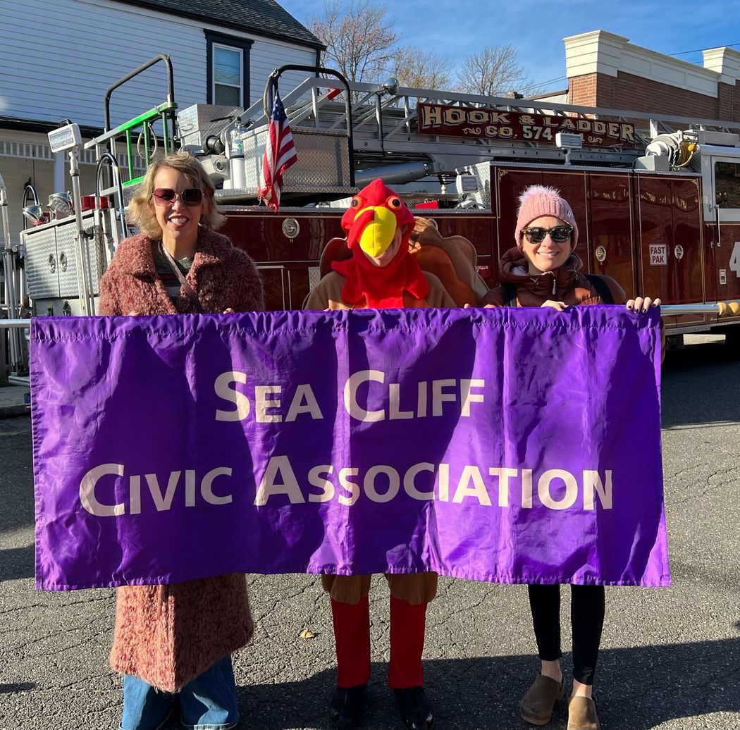 Volunteers, one in a turkey costume, with the Sea Cliff Civic Association banner